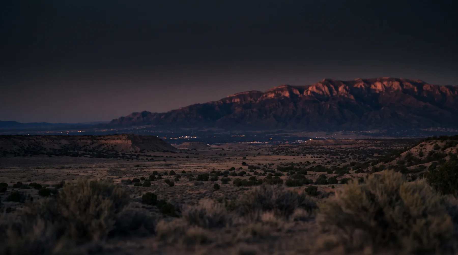 The Sandia Mountains glowing at dusk over the New Mexico high desert, home of Viceroy NM headquarters since 2018